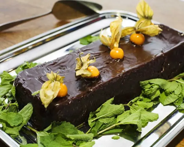 En glansig chokladtårta, perfekt för påsk, dekorerad med physalis och mynta. En härlig påsktårta choklad!
