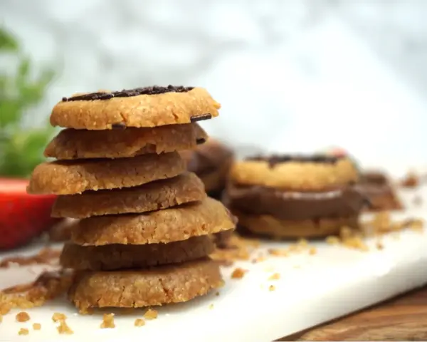 En hög med hembakade kakor, perfekta att baka med Nutella. En jordgubbe ligger bredvid.