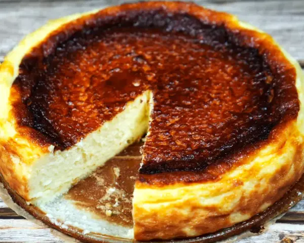 En krämig baskisk cheesecake med en härligt bränd yta, redo att avnjutas.