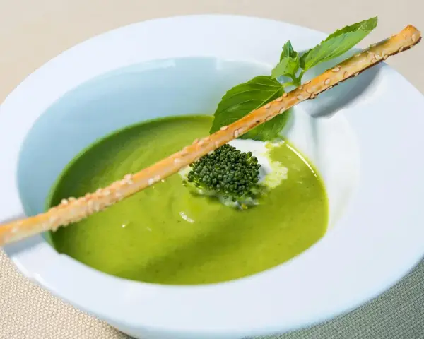 Grön ärtsoppa med en krispig brödpinnar och en liten broccoli-bukett. Perfekt för att se om man kan frysa ärtsoppa för framtida middagar.