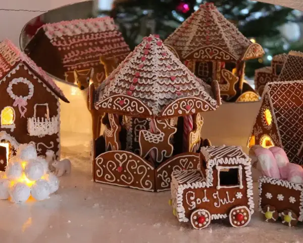 En hel by av pepparkakshus, med ett karusellhus i mitten och ett tåg som säger "God Jul".