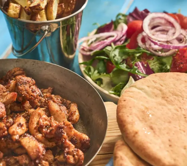 En härlig grekland mat-upplevelse med saftigt kött, krispiga pommes, fräsch sallad och fluffigt pitabröd.
