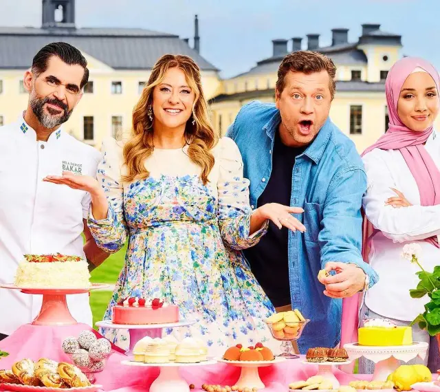 Fyra glada personer poserar vid ett bord fyllt med bakverk. De är med i Hela Sverige Bakar, redo att visa upp sina skapelser.
