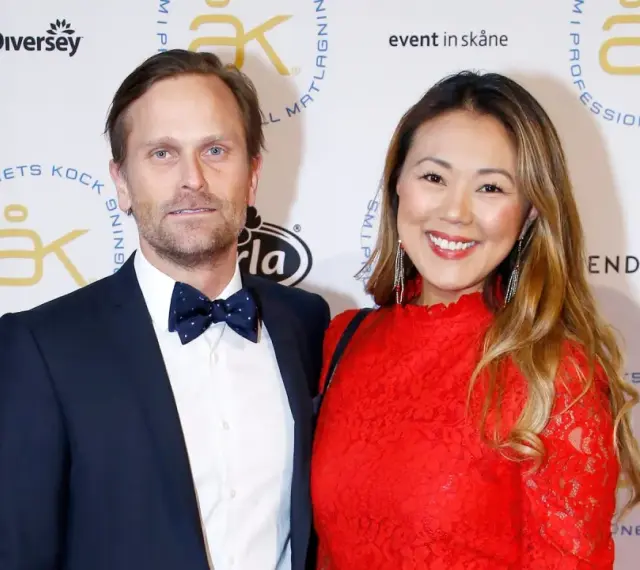 Jennie Wallden strålar i rött bredvid sin partner på en gala.