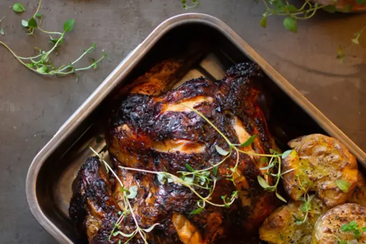 Helstekt kyckling med krispiga potatisar i ugnsform. Perfekt kyckling temperatur ger en saftig och god måltid.