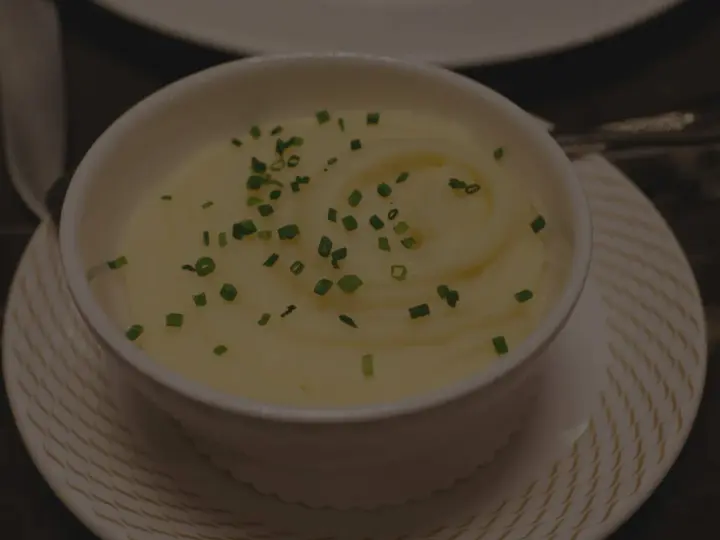Krämig potatismos i en vit skål, garnerad med gräslök. Perfekt för att frysa potatis och njuta av senare.