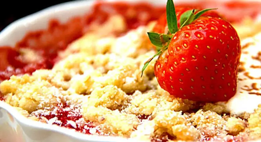 En härlig crumble med jordgubbar, perfekt att baka med. En saftig jordgubbsbotten toppad med smuldeg och en färsk jordgubbe som dekoration.