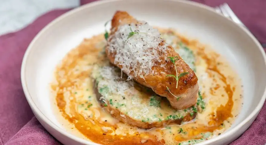 En saftig kycklingfilé toppad med parmesan och örter, serverad på en bädd av krämig grönsakspuré med en smakrik sås. Ett perfekt middagstips vardag!