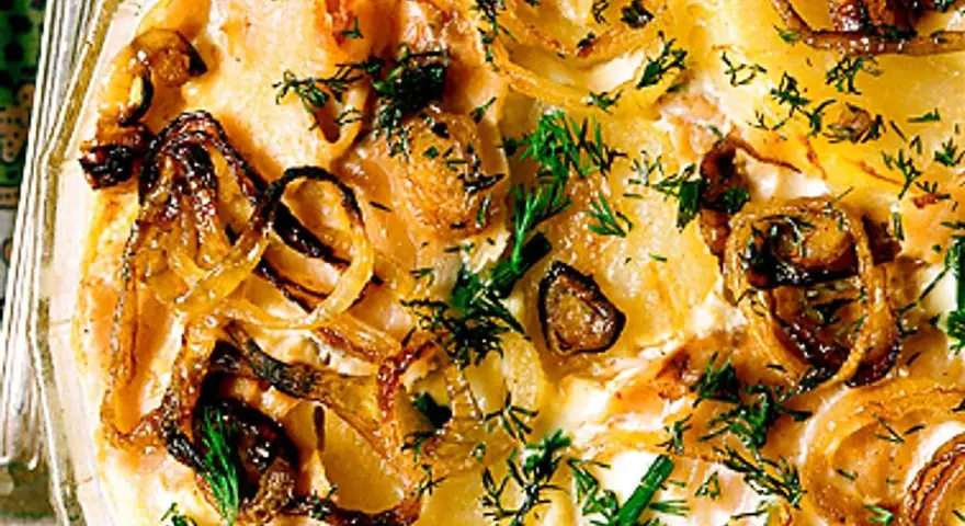 Laxpudding med gravad lax, potatis och karamelliserad lök, toppad med färsk dill. En klassisk svensk rätt.