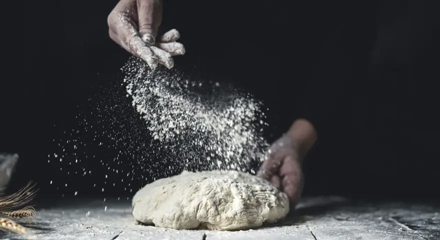 Händer strör mjöl över deg. En berättelse om svenskt bröd och kärleken till bakning med bra **bread flour svenska**.