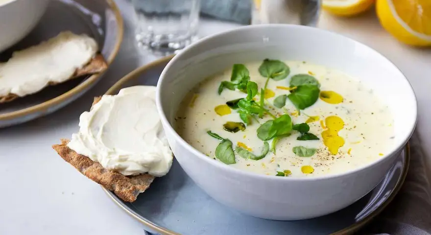 Krämig purjolökssoppa med färska örter och citron, serverad med knäckebröd och färskost.