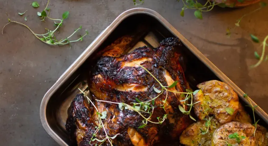 Helstekt kyckling med krispiga potatisar i ugnsform. Perfekt kyckling temperatur ger en saftig och god måltid.