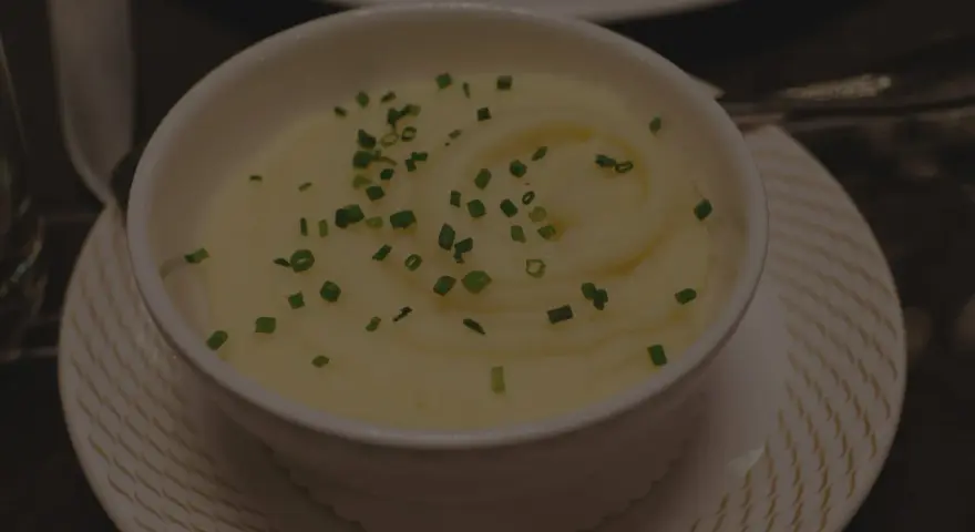Krämig potatismos i en vit skål, garnerad med gräslök. Perfekt för att frysa potatis och njuta av senare.