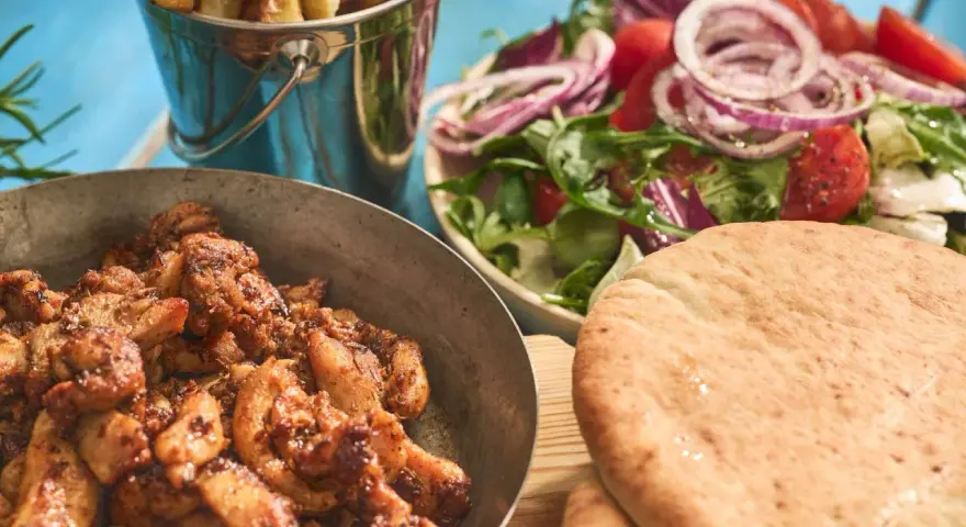 En härlig grekland mat-upplevelse med saftigt kött, krispiga pommes, fräsch sallad och fluffigt pitabröd.