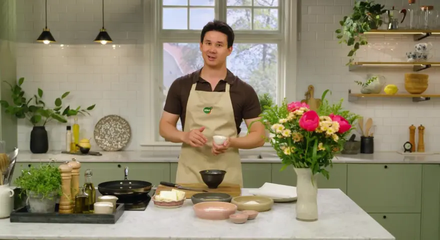 Filip Poon i köket, redo att laga mat med en bukett blommor bredvid.