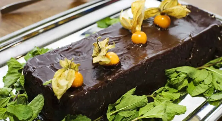 En glansig chokladtårta, perfekt för påsk, dekorerad med physalis och mynta. En härlig påsktårta choklad!
