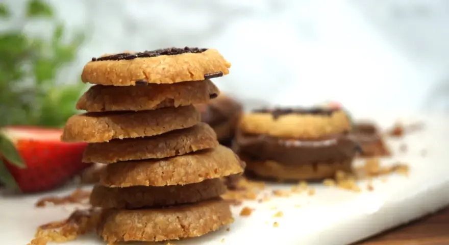 En hög med hembakade kakor, perfekta att baka med Nutella. En jordgubbe ligger bredvid.