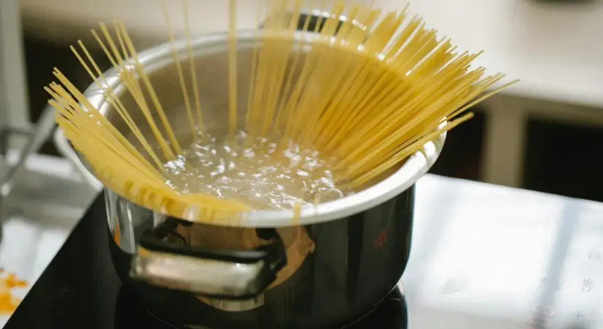 Spaghetti kokas i en kastrull på spisen. En perfekt mängd, för att veta hur mycket pasta per person som behövs.