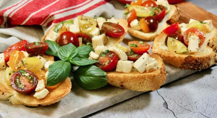Bruschetta med mozzarella, färska tomater och basilika på rostat bröd. En härlig sommardelikatess.