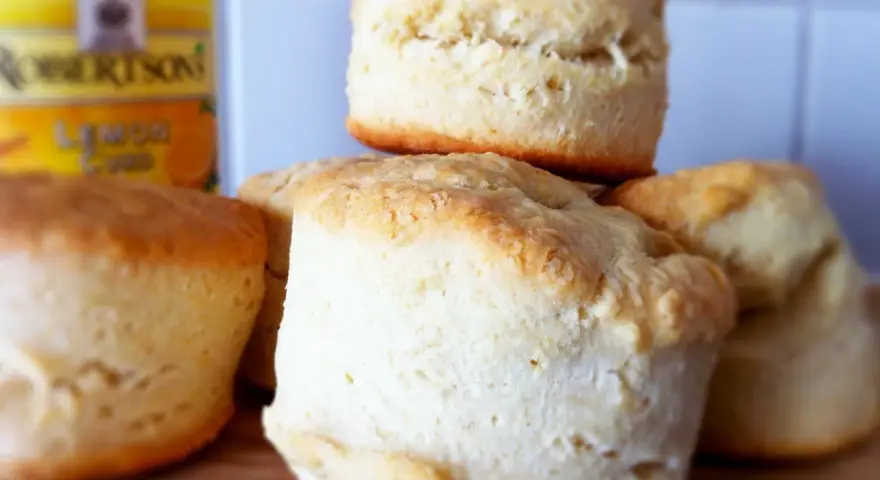 En hög med fluffiga engelska scones, redo att serveras med Robertsons Lemon Curd.