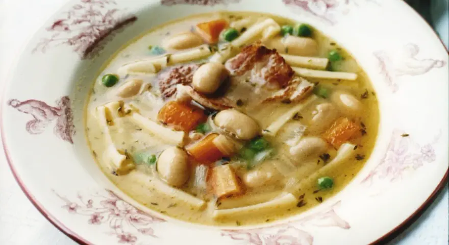 En skål med minestronesoppa med fläsk, bönor, morötter, ärtor och pasta.