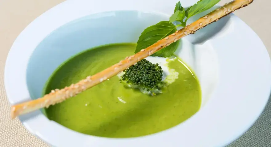 Grön ärtsoppa med en krispig brödpinnar och en liten broccoli-bukett. Perfekt för att se om man kan frysa ärtsoppa för framtida middagar.
