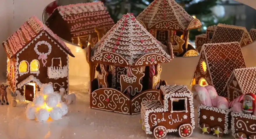 En hel by av pepparkakshus, med ett karusellhus i mitten och ett tåg som säger "God Jul".
