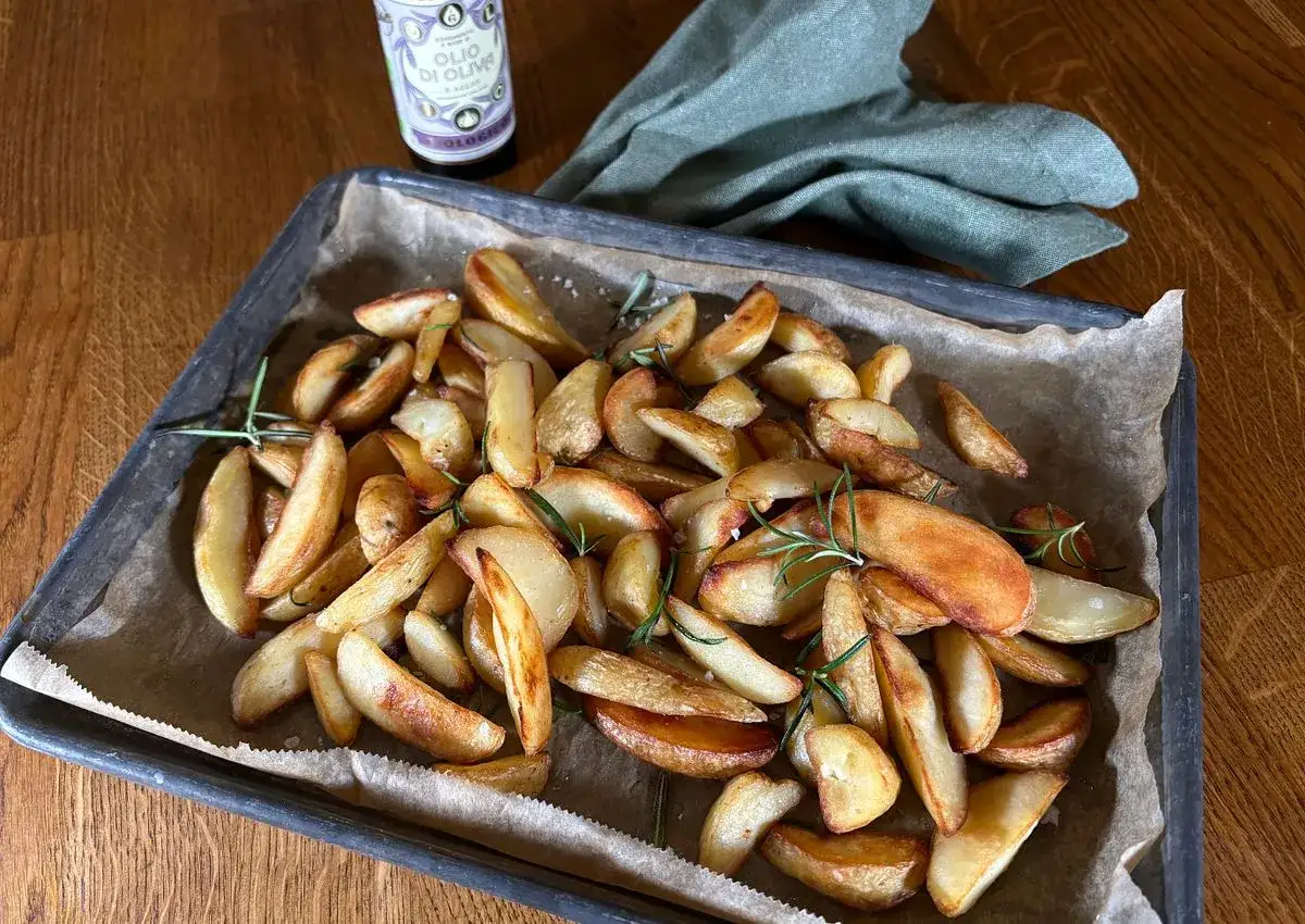 Ugnsrostade potatisklyftor med rosmarin och flingsalt, redo att avnjutas. Perfekt att frysa in f&ouml;r snabb middag.