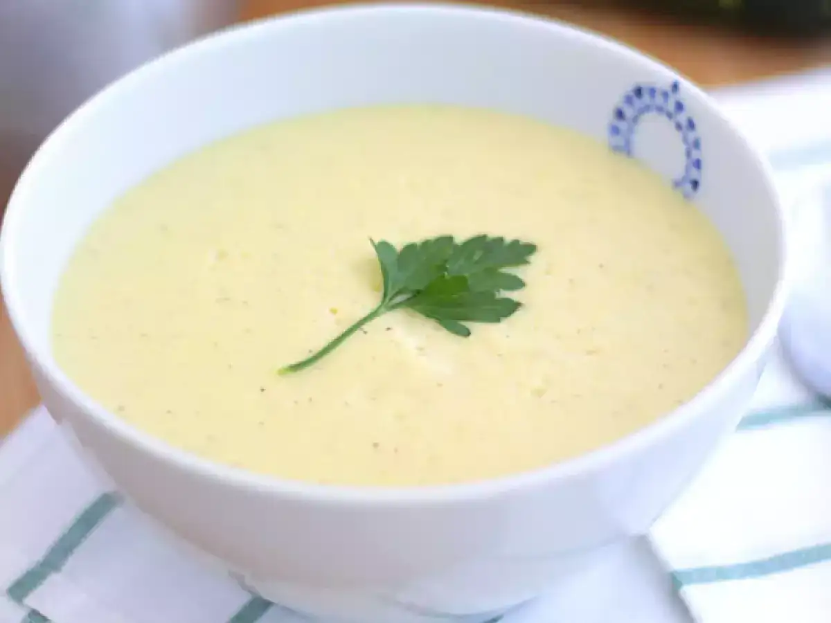 Krämig squashsoppa med potatis, garnerad med persilja, serverad i en vit skål med blått mönster.