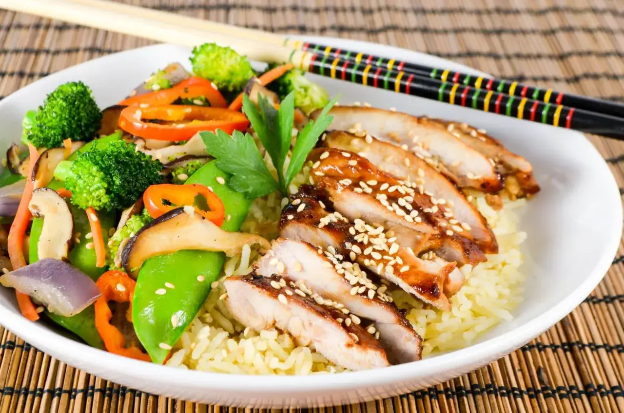 En skål med ris, teriyaki kyckling, broccoli, sockerärtor och paprika. En läcker måltid!