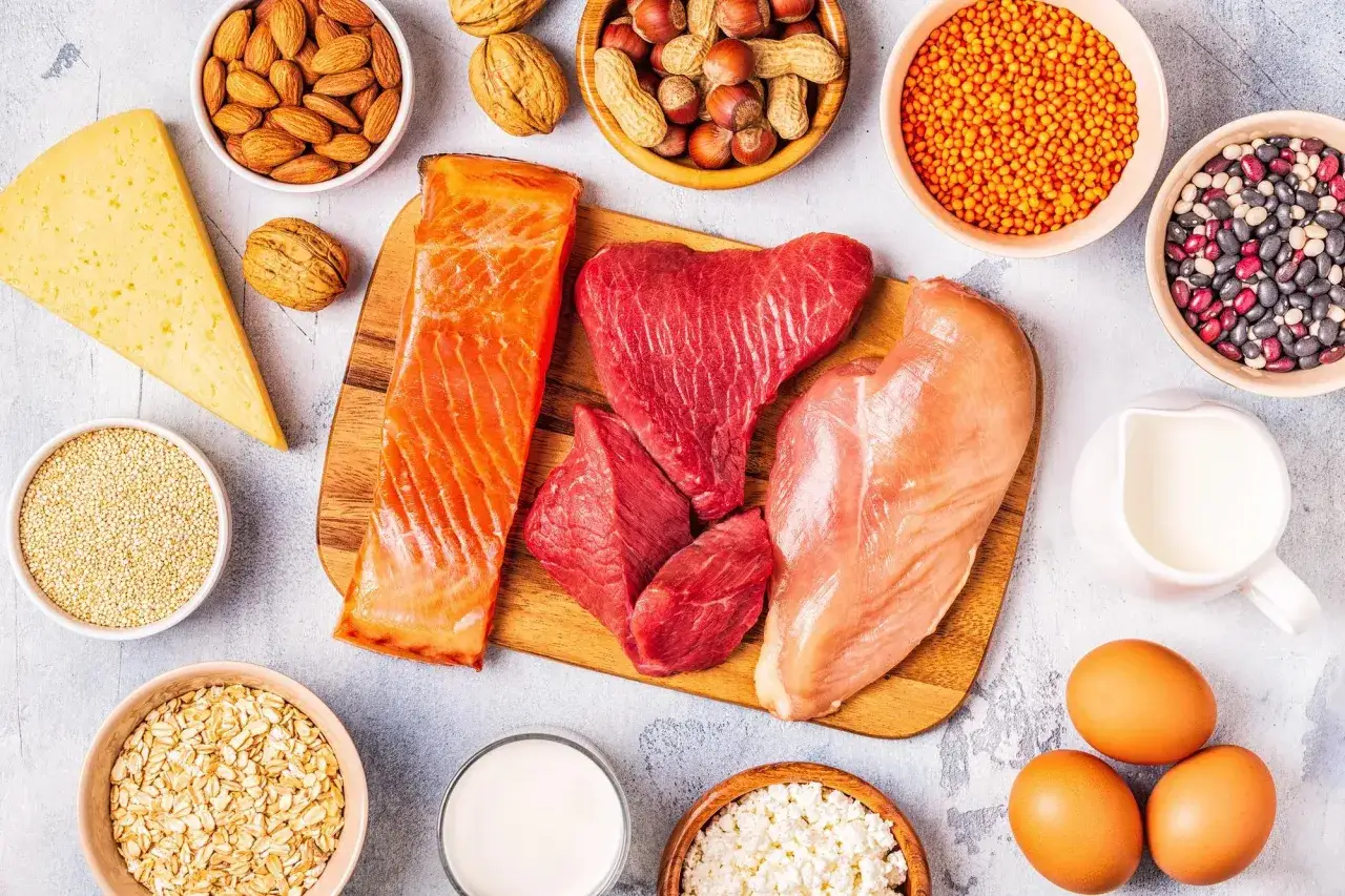 En variation av proteinrika livsmedel: lax, nötkött, kyckling, ägg, ost, nötter, linser, bönor, havre och quinoa. Bra för att planera hur mycket protein per dag.