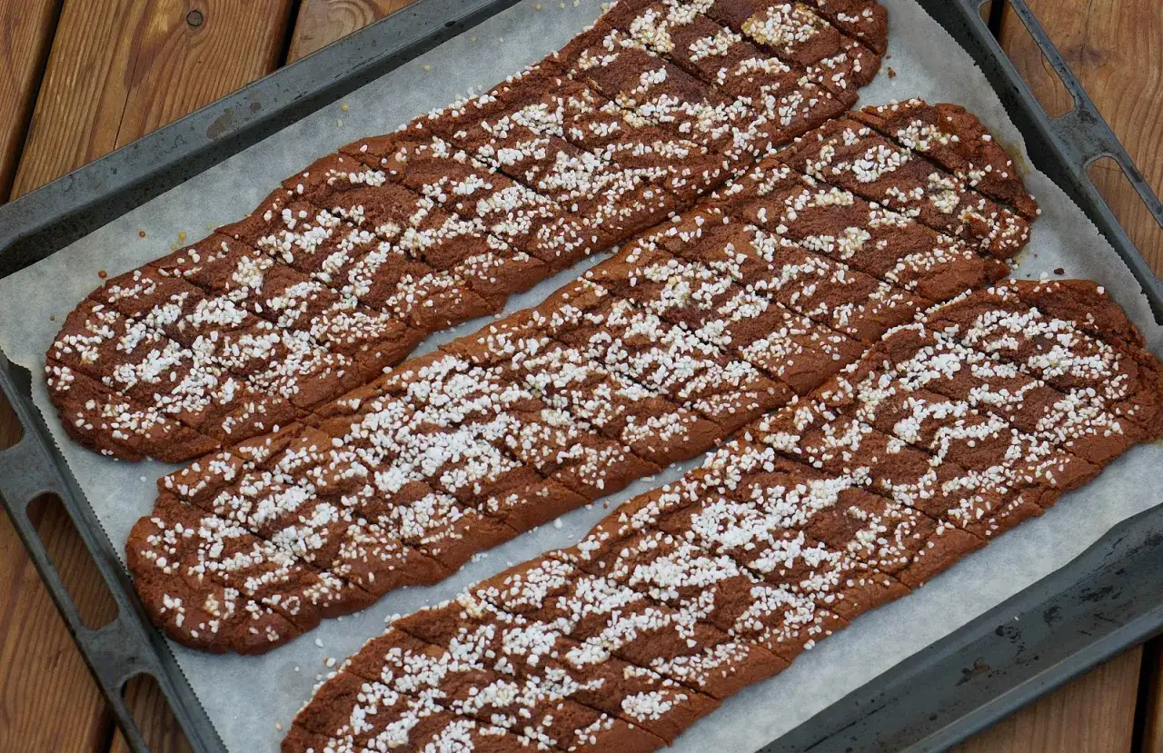 Tre långa, sega chokladsnittar med pärlsocker på en plåt. Perfekta för fikat!