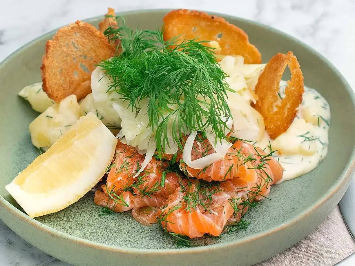 En läcker portion lax och potatis med dill, citronskiva och knapriga krutonger.