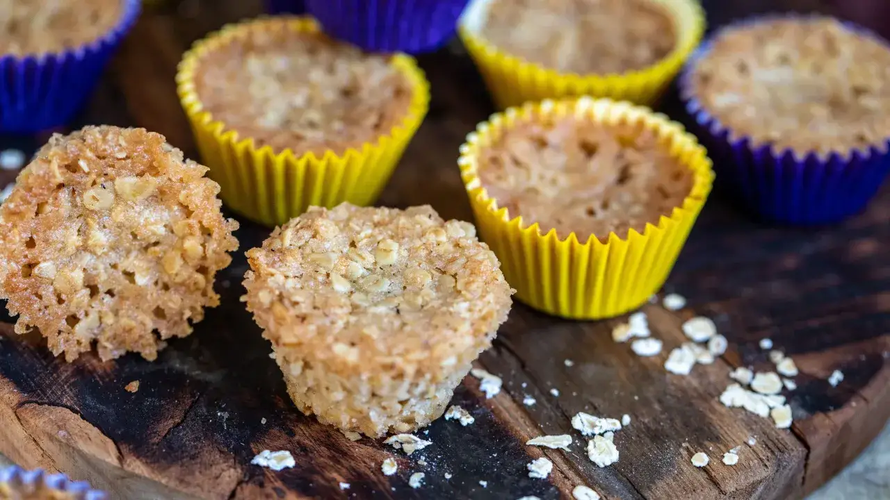 Fredriks fika: knapriga havrekakor och muffins i färgglada formar på en träbricka.