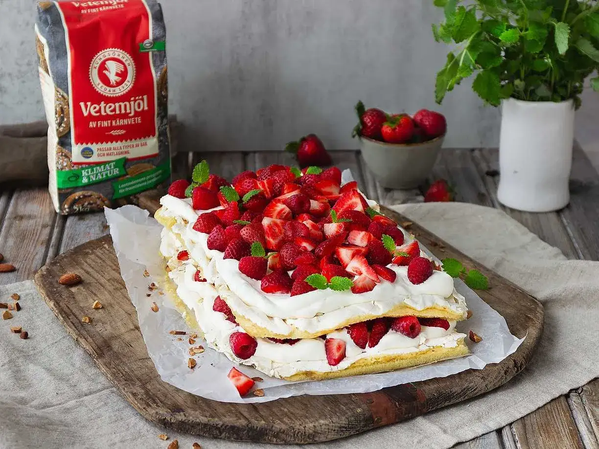En härlig pinocchiotårta i långpanna, fylld med vispgrädde och toppad med färska jordgubbar och hallon. Perfekt för sommaren!