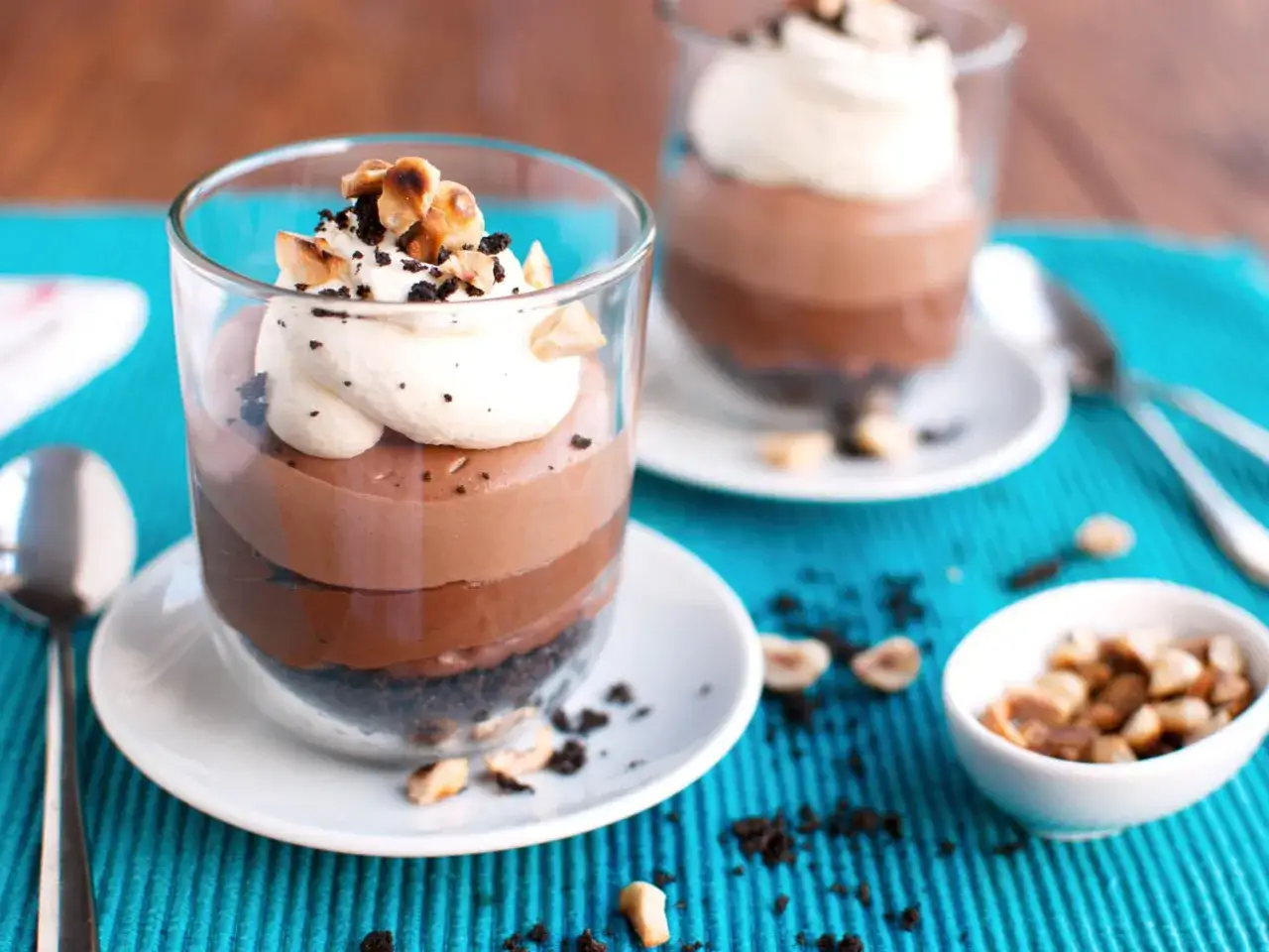 En läcker nutella cheesecake i glas, toppad med vispgrädde och hasselnötter. En dröm för alla chokladälskare!