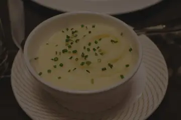 Krämig potatismos i en vit skål, garnerad med gräslök. Perfekt för att frysa potatis och njuta av senare.