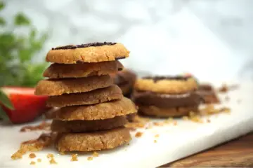 En hög med hembakade kakor, perfekta att baka med Nutella. En jordgubbe ligger bredvid.