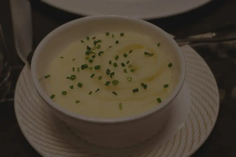 Krämig potatismos i en vit skål, garnerad med gräslök. Perfekt för att frysa potatis och njuta av senare.