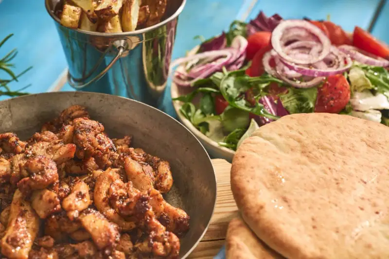 En härlig grekland mat-upplevelse med saftigt kött, krispiga pommes, fräsch sallad och fluffigt pitabröd.